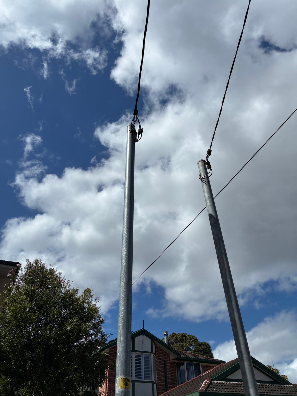 Two private power poles carrying overhead service lines to a Sydney home